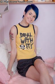In Her Shorts And Top A Blue Hair Teenager Waits On The Bed